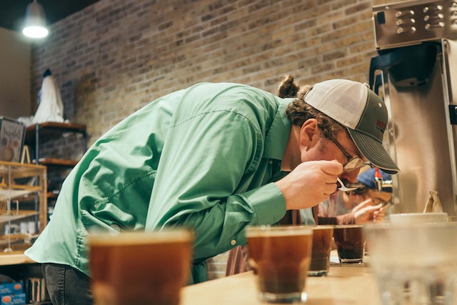 A person trying to experience the elements of tasting coffee.