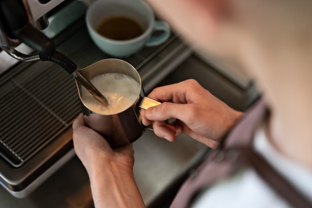 barista steaming milk on espresso machine